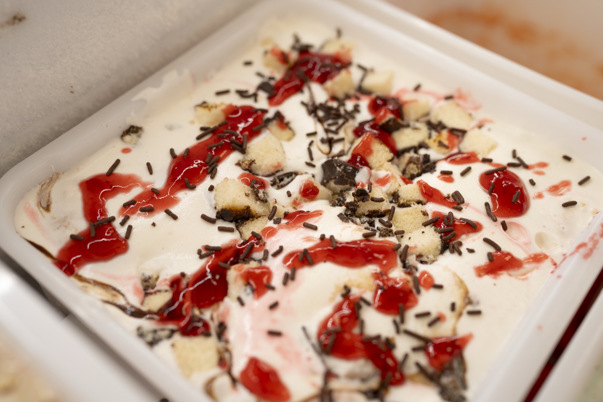 Artisanal ice cream with toppings and strawberry sauce